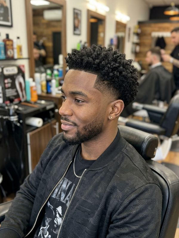Low taper fade with sponge curls, twists, or locs